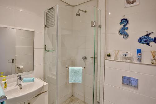 巴利托Zimbali Lakes Boulevard Suites 103的带淋浴和盥洗盆的浴室