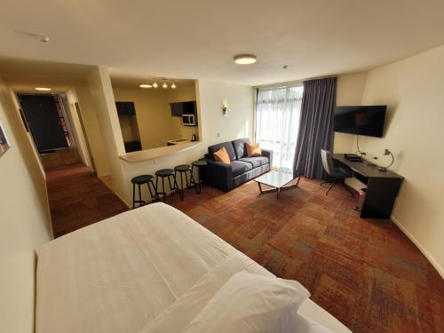 奥克兰城市帆船汽车旅馆的酒店客房设有床和客厅。