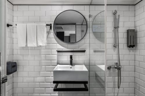 恒春古城河堤垦丁渡假酒店的白色的浴室设有水槽和镜子