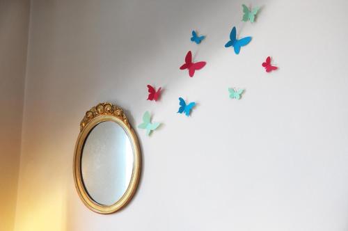 米兰阿莱格拉之家住宿加早餐旅馆的墙上的镜子,上面有蝴蝶
