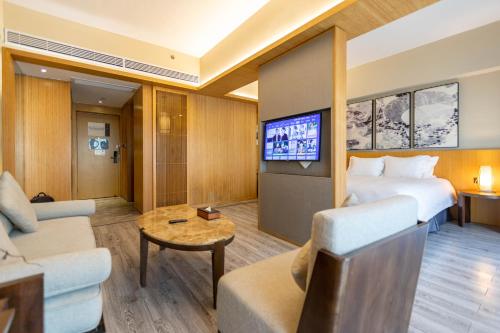 杭州杭州西溪南庐君亭酒店的一间酒店客房,配有一张床和一台电视