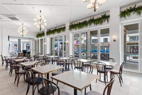 汉密尔顿Ramada by Wyndham, Hamilton City Center的餐厅设有桌椅和窗户。
