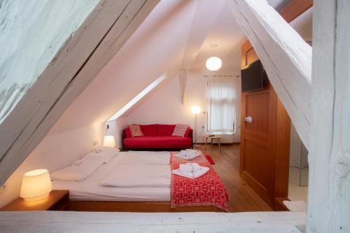 克拉尼斯卡戈拉Pr'Gavedarjo Eco Heritage B&B的一间设有床铺和红色沙发的房间