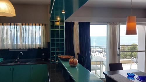 阿特米达Vicky's place的一间厨房,配有绿色橱柜,享有海景