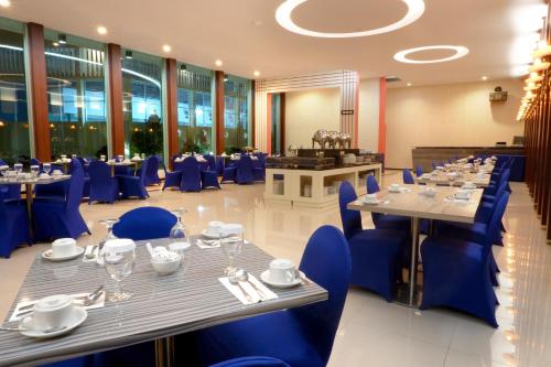 LepoleopSahid Azizah Syariah Hotel and Convention Kendari的一间配备有蓝色椅子和桌子的用餐室