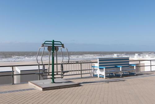 米德尔克尔克Caravan Aan Zee Arnani的海滩上两把长椅和一根灯杆