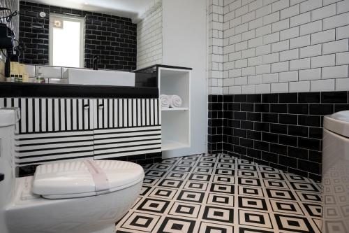 巴加Richmonde Ananta Elite Luxurious Villa & Apartments,Goa的黑白浴室设有卫生间和水槽