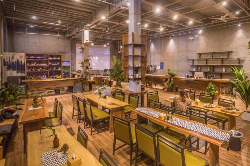 桂林桂林厂舍酒店的餐厅设有木桌和椅子,种有植物