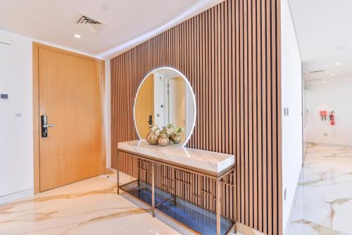 迪拜Lavish & Equipped oceanfront 2 BR facing Ain Dubai的一间带圆形镜子和水槽的浴室