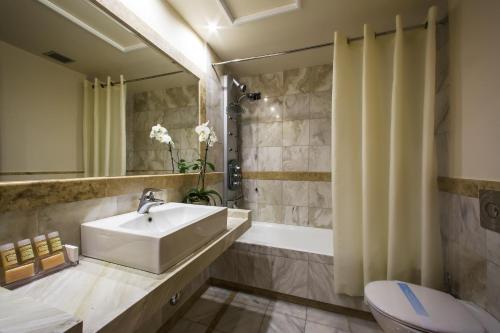 雅典德科里亚酒店的一间带水槽、浴缸和卫生间的浴室