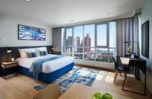 曼谷莎玛阿索克湖景服务式公寓的配有一张床、一张书桌和一扇窗户的酒店客房