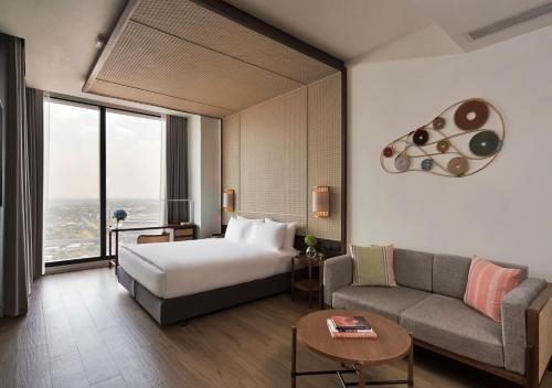坤敬Ad Lib Hotel Khon Kaen的酒店客房,配有床和沙发
