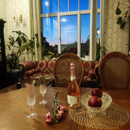文茨皮尔斯Ventspils apartamenti pie Rātslaukuma的一瓶葡萄酒和苹果坐在桌子上