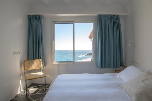 卡达克斯Sa Guineu的一间卧室设有一张床和一个海景窗户