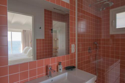 卡达克斯Sa Guineu的红色瓷砖浴室设有水槽和镜子