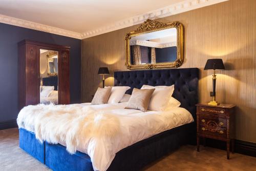 Numansdorp作品一号精品酒店的卧室配有一张大床,墙上装有镜子