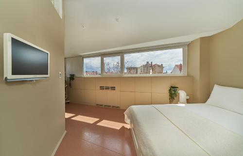 斯普利特Design Hostel One的一间卧室配有一张床和一台平面电视