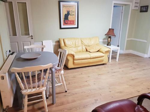 Dromore WestCoastal Cottage的客厅配有桌椅和沙发
