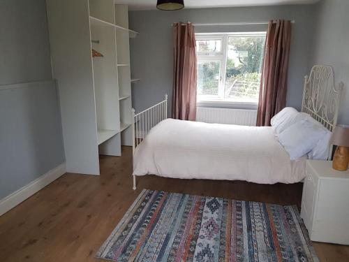 Dromore WestCoastal Cottage的一间卧室设有床、窗户和地毯。