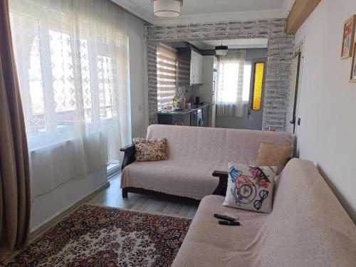 安塔利亚Lara plaj yakın Aileler için 1+1 mükemmel daire的带沙发和窗户的客厅
