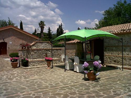 弗拉克维尔玛拉汀索西埃塔阿格里科拉MG弗洛普朗特酒店的一个带绿伞和椅子的庭院