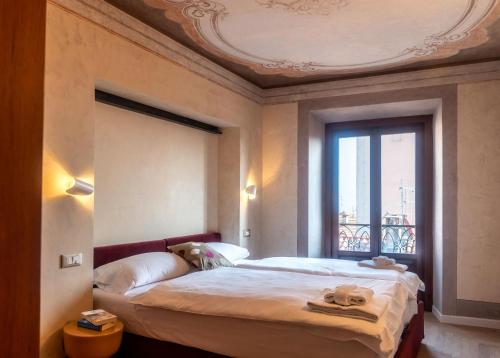 梅纳焦Leoni 7的一间卧室设有一张大床和一个窗户。