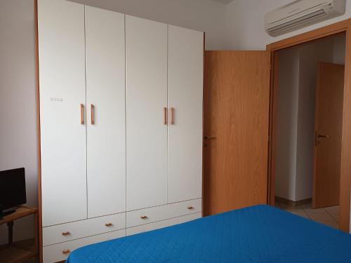 里米尼Appartamenti Carlotta的卧室配有白色橱柜和蓝色的床。