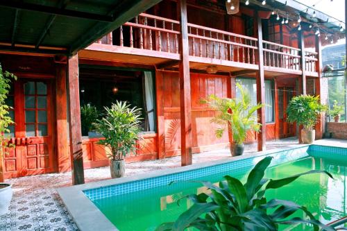Ða GiaNinh Binh Green Homestay的大楼前带游泳池的房子