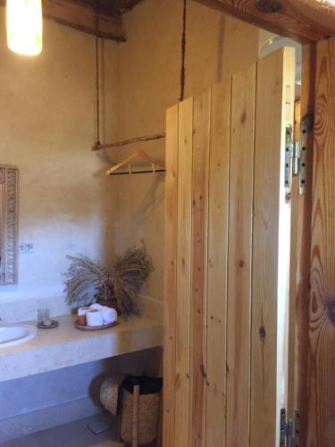 锡瓦Tanirt ecolodge的一间带木门和水槽的浴室