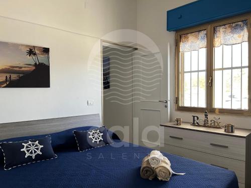 普罗斯西托角Villa Antonietta的一间卧室设有蓝色的床和窗户。