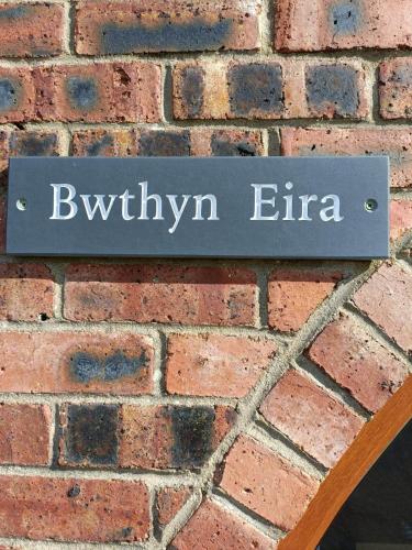 兰盖夫尼Bwthyn Eira的砖墙上的一个标志,上面写着伯里时代