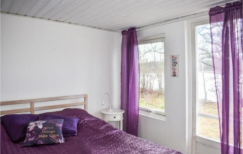 LyckebyGorgeous Home In Lyckeby With House Sea View的一间卧室配有紫色窗帘、一张床和一个窗户