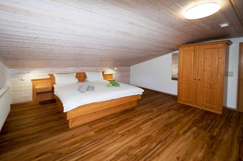 比绍夫斯维森Ferienwohnung Wiesenlehen的铺有木地板的客房设有一间带大床的卧室