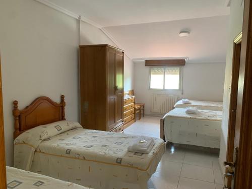 圣西普安－德比尼亚斯塞凯伊罗斯旅馆的一间卧室设有两张床、一张桌子和一个窗口。