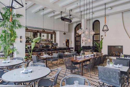 洛杉矶Hotel Figueroa, Unbound Collection by Hyatt的一间带桌椅的餐厅和一间酒吧