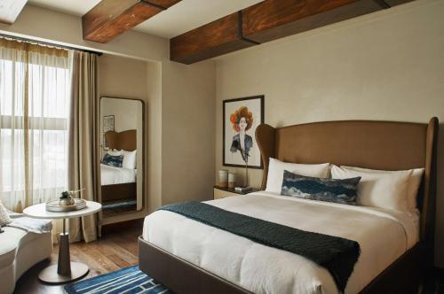 洛杉矶Hotel Figueroa, Unbound Collection by Hyatt的一间卧室配有一张大床和镜子