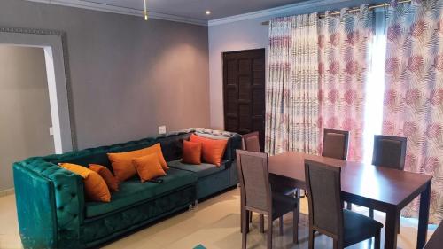 焦济尼Labas Travellers Guesthouse的客厅配有绿色沙发和桌子