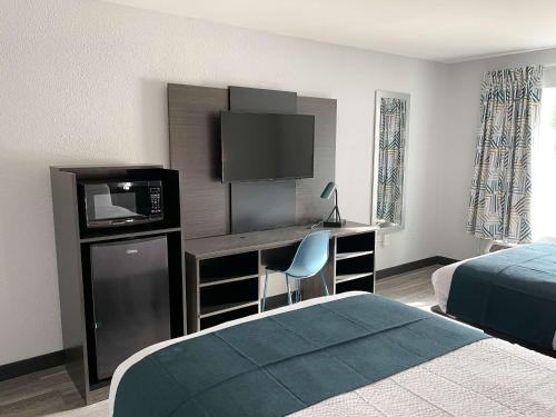 西哥伦比亚Motel 6 West Columbia SC Airport的酒店客房配有一张床和一张书桌及一台电视
