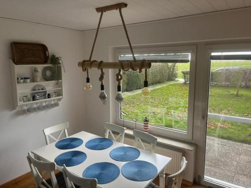 纽哈灵吉塞尔Kleine Scholle的一间设有蓝色和白色桌子及窗户的用餐室