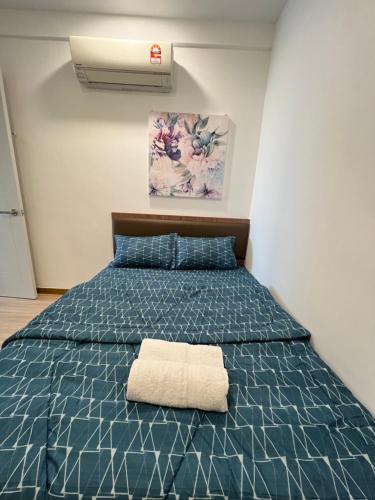 马六甲SNHomestay1826 Sea View @ The Wave Residence的一间卧室配有一张蓝色的床,上面有毛巾