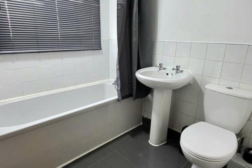 贝德沃思Cosy 3 double bed flat sleeps 6的浴室配有卫生间、盥洗盆和浴缸。