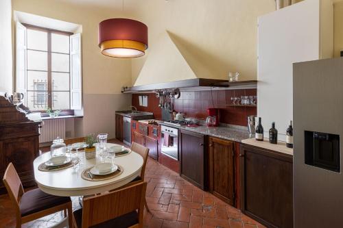 佛罗伦萨Palazzo Roselli Cecconi Apartments的厨房配有桌子和一些椅子