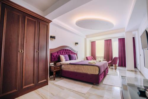 奥赫里德Villa Afrodita City Center的一间卧室配有一张紫色的床和一张桌子