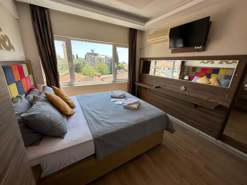 安塔利亚二十酒店的一间卧室配有一张带窗户的床和一台电视