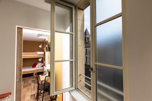 Nieul-sur-lʼAutiseL'Auberge des Artistes的一间设有滑动玻璃门的房间和一间卧室