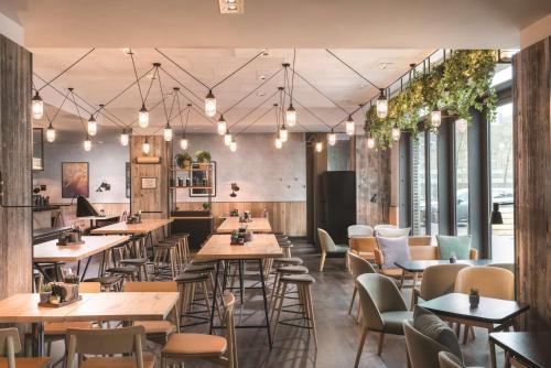 哥本哈根哥本哈根阿迪娜公寓式酒店的餐厅设有桌椅和窗户。