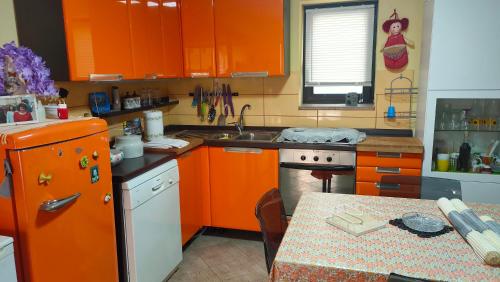 锡尔维玛丽娜Casa Vale的厨房配有橙色橱柜和桌子