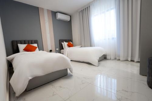安曼Al Kawther Hotel Apartments的一间卧室设有两张床和大窗户