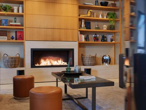 柏林柏林米特区阿迪纳公寓式酒店的客厅设有壁炉和桌子