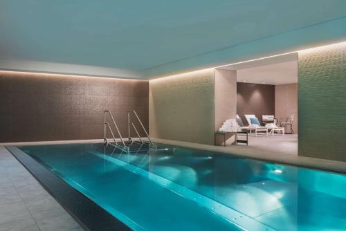 莱比锡莱比锡阿迪娜公寓酒店的游泳池位于带客厅的房间